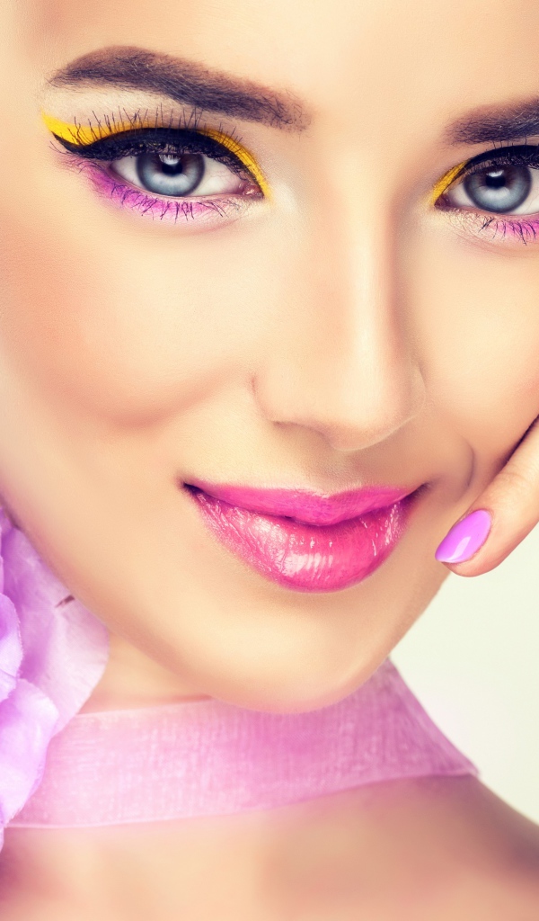 Красивая молодая девушка с ярким макияжем и сиреневым цветком на шее