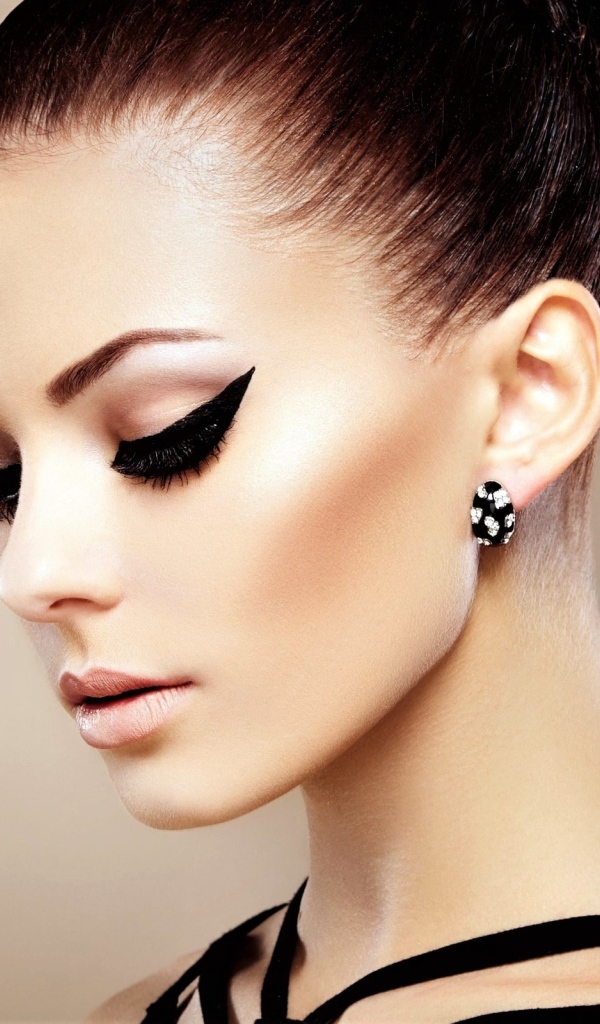 Красивая молодая девушка с макияжем и красивыми серьгами