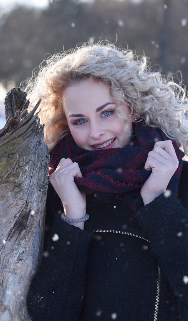Голубоглазая блондинка у сухого дерева зимой
