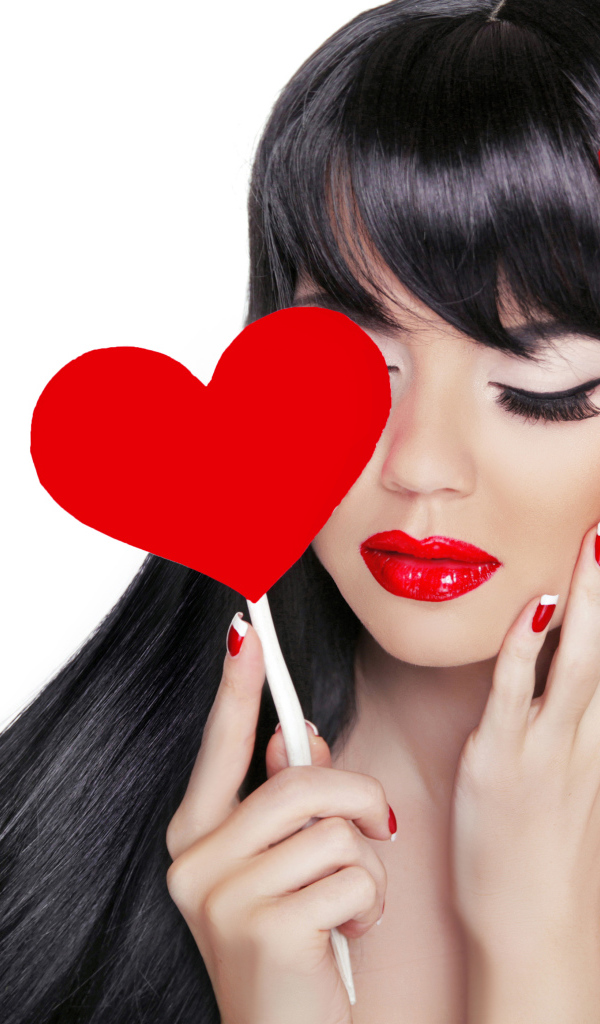 Яркая брюнетка с красным сердцем в руке на белом фоне