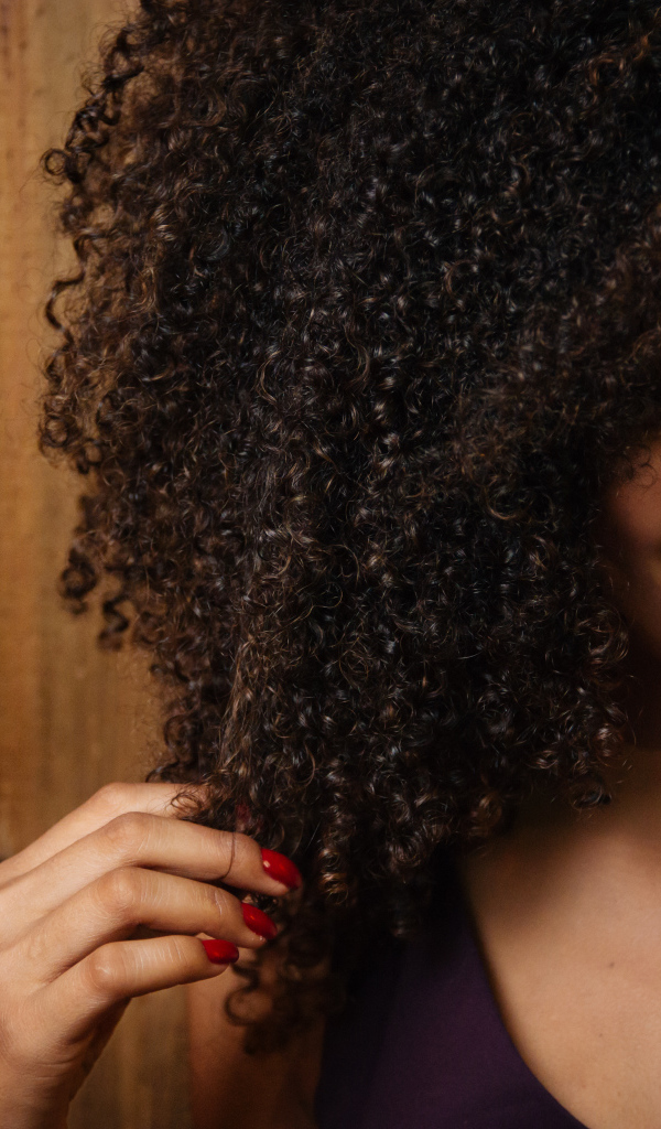 Кучерявая темнокожая девушка с красивой улыбкой 