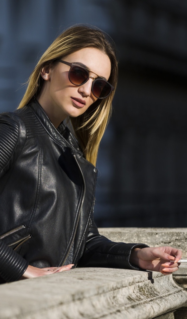 Дерзкая девушка в черной кожаной куртке и очках