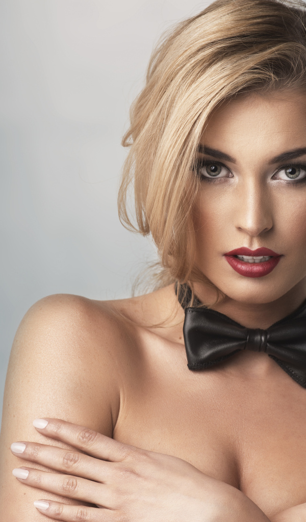 Нежная девушка блондинка с галстуком бабочкой на шее