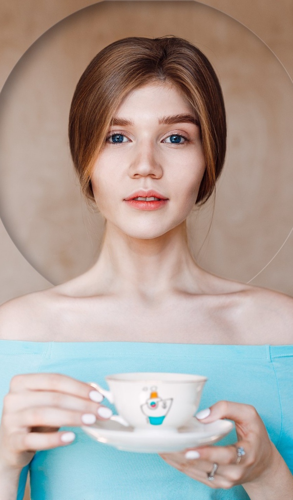 Нежная голубоглазая девушка с чашкой 