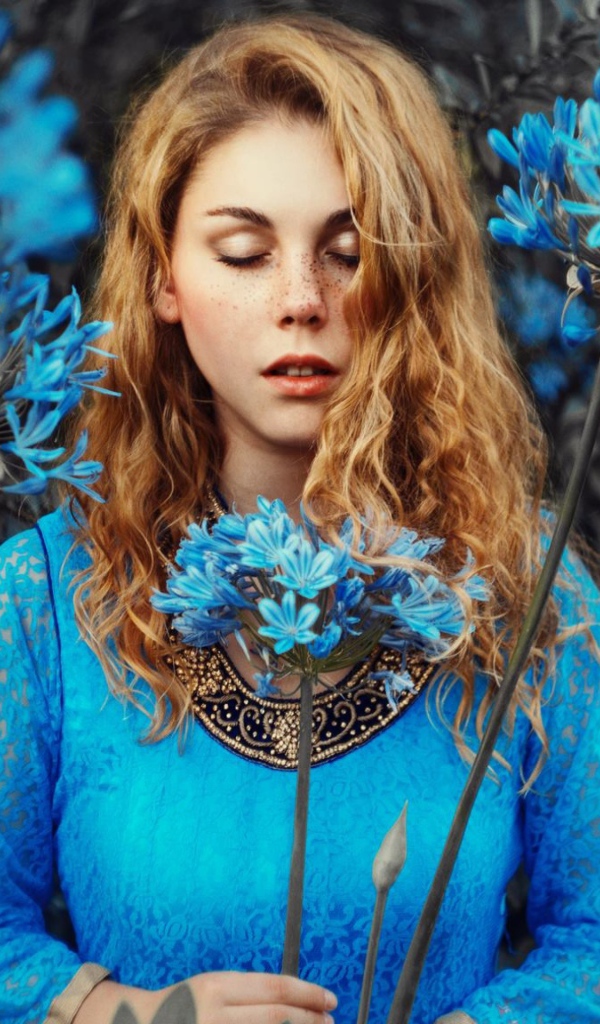 Мечтательная девушка с голубыми цветами 