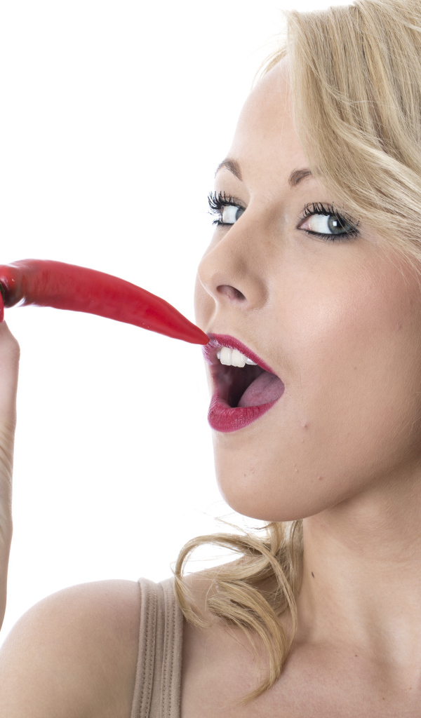 Девушка блондинка с красным острым перцем в руке 