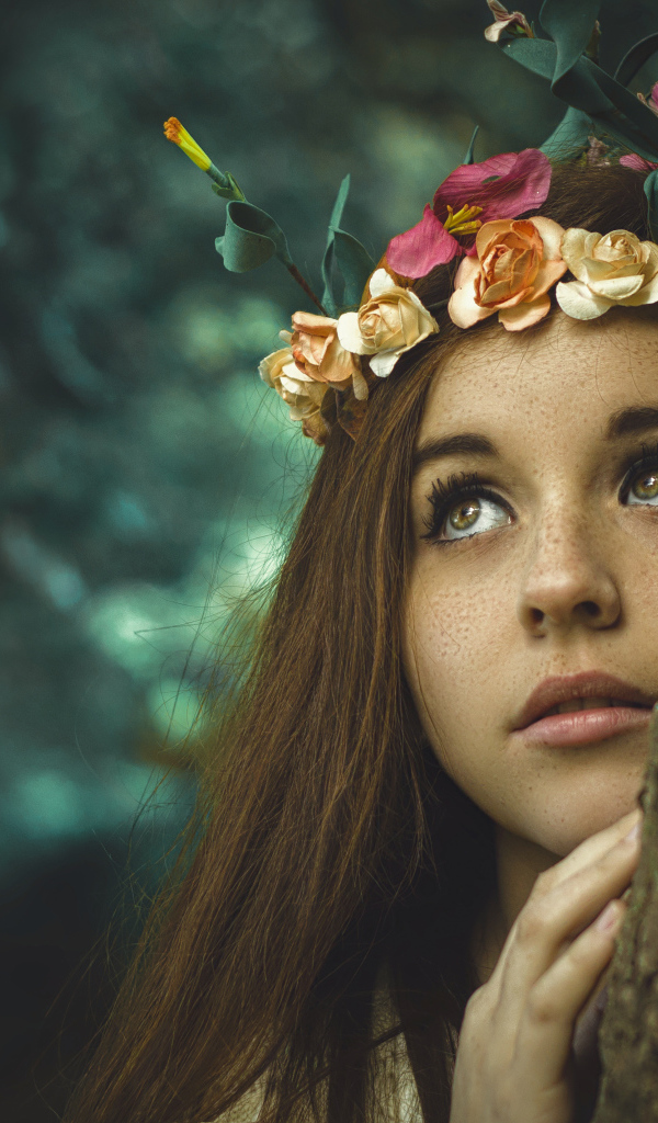 Девушка с венком на голове у дерева 