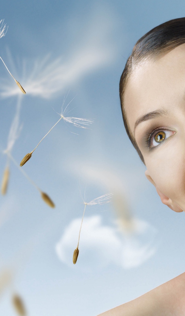 Счастливая девушка с одуванчиком в руке 