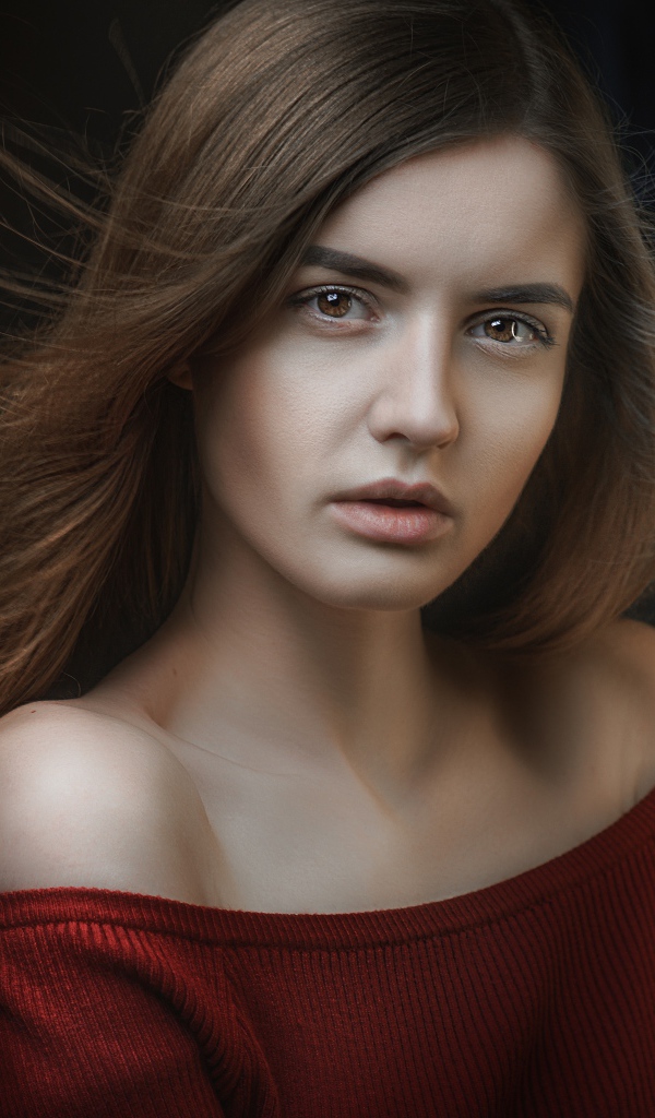 Длинноволосая красивая девушка в красном свитере