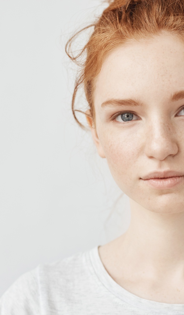 Рыжеволосая девушка на сером фоне