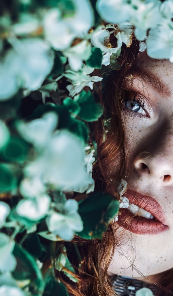 Рыжеволосая девушка с веснушками в белых цветах 