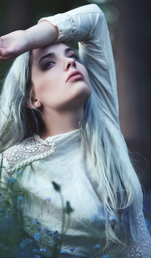 Грустная молодая блондинка в голубых цветах