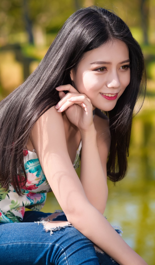 Улыбающаяся красивая девушка азиатка у воды