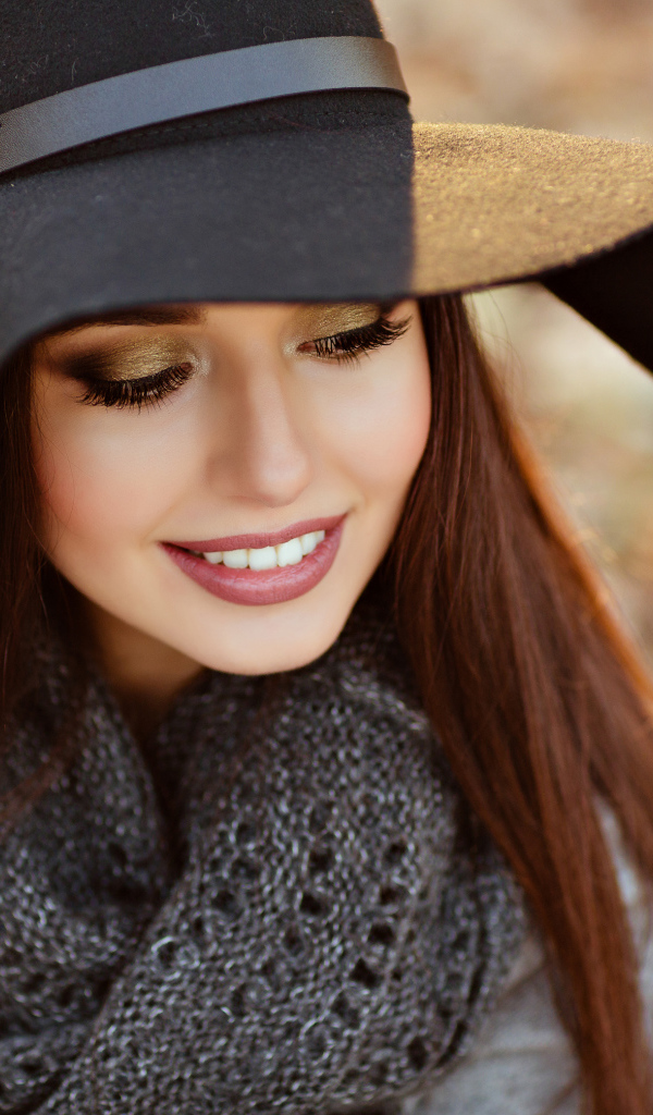 Улыбающаяся шатенка в большой черной шляпе