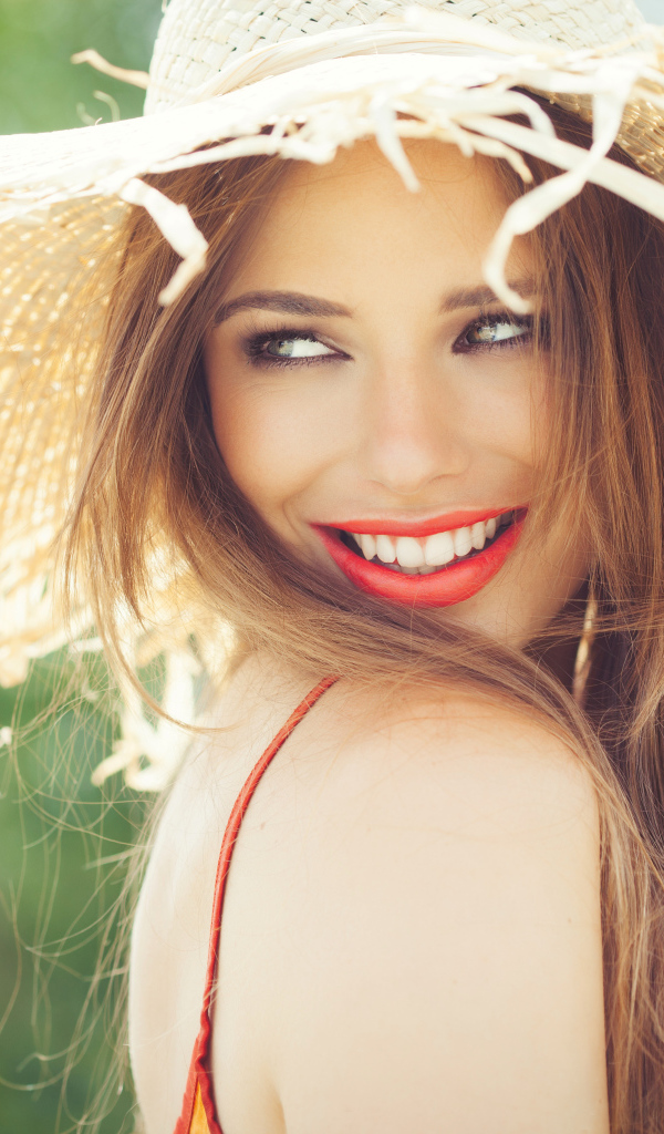 Улыбающаяся девушка в соломенной шляпе летом