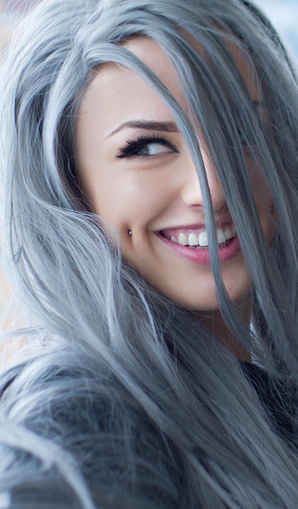 Улыбающаяся эпатажная девушка с пирсингом