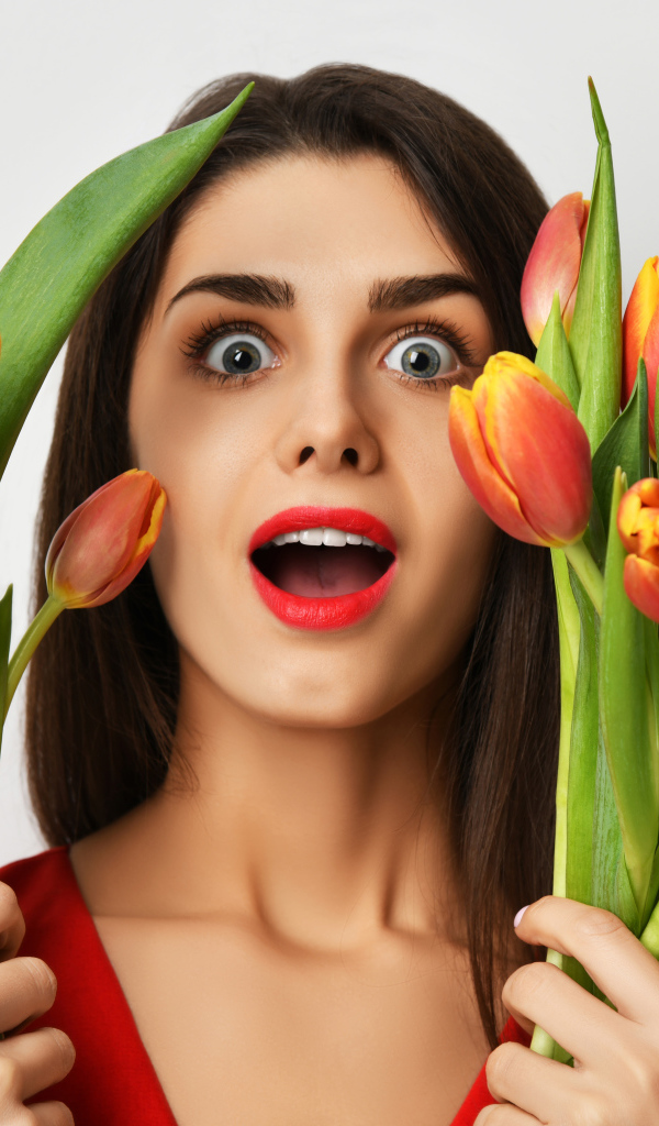 Удивленная шатенка с букетами тюльпанов