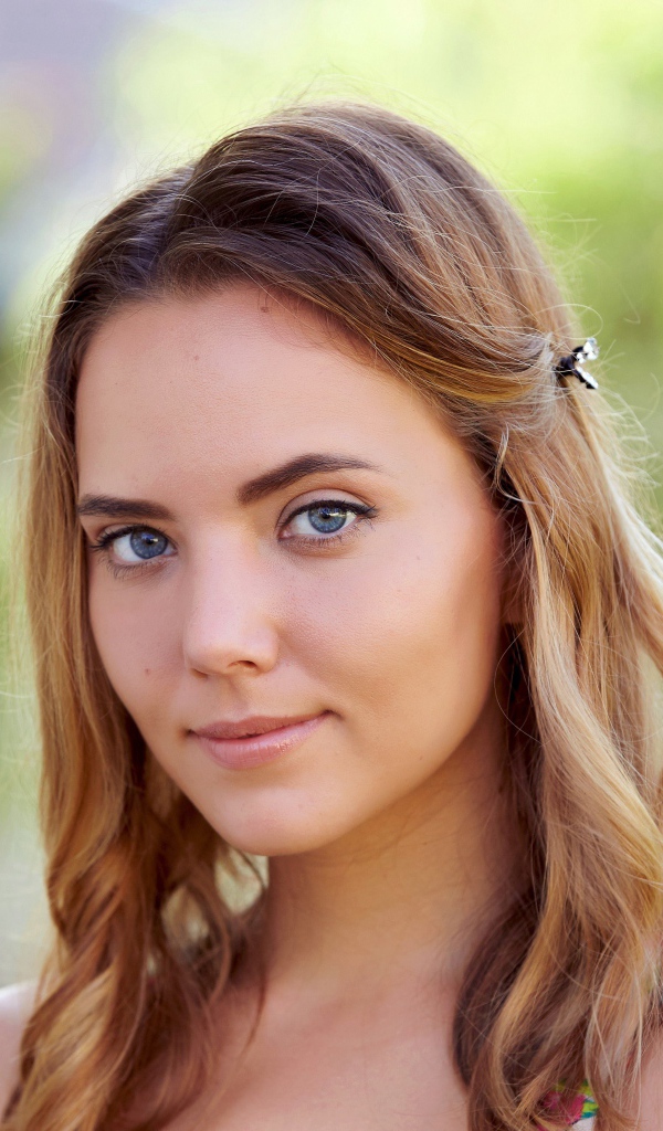 Нежная голубоглазая шатенка с заколкой в волосах 