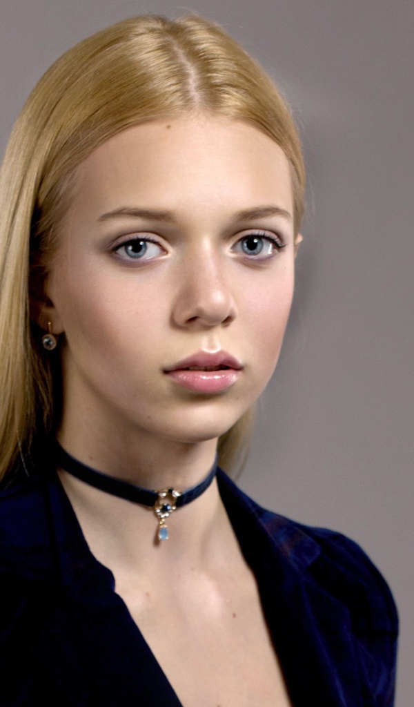 Нежная голубоглазая девушка с украшением на шее 