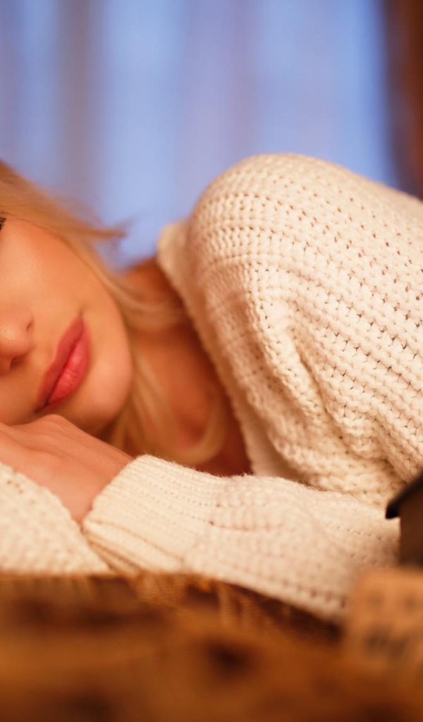 Нежная спящая блондинка в белом свитере 