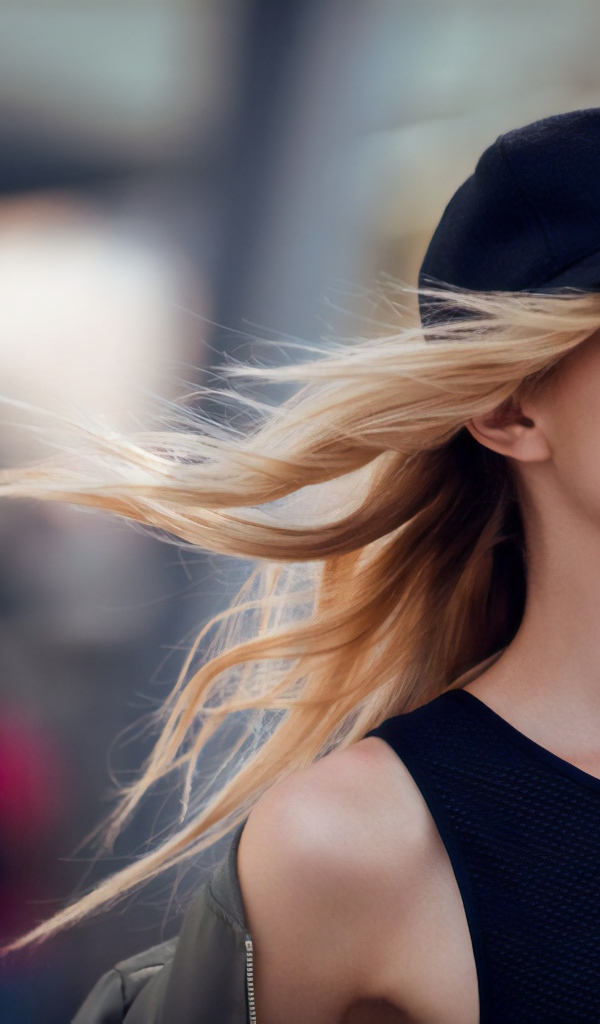 Молодая блондинка в солнечных очках и черной кепке 