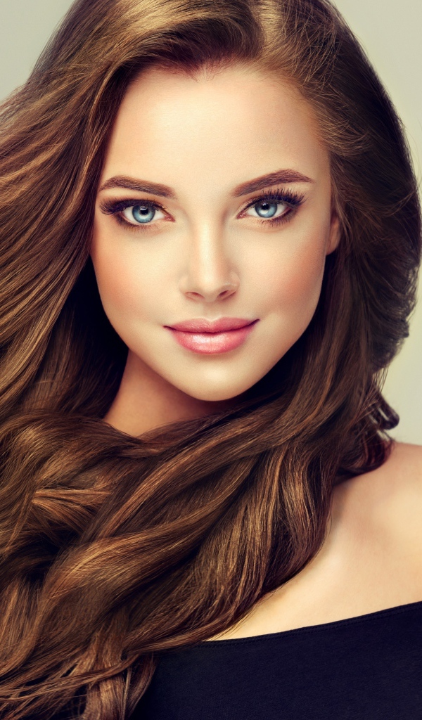 Молодая голубоглазая девушка с красивыми длинными волосами