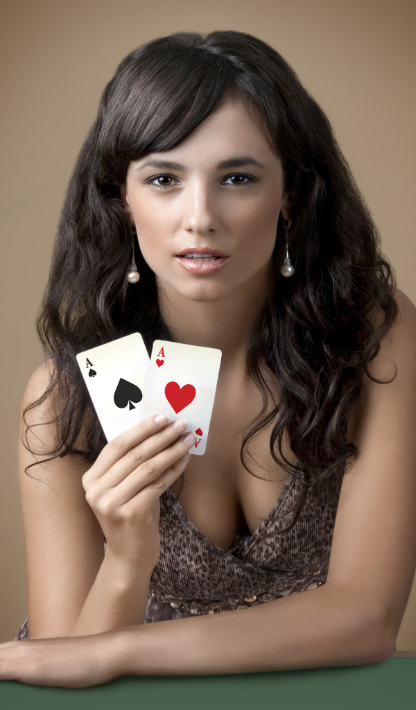 Молодая брюнетка с двумя карточными тузами в руке