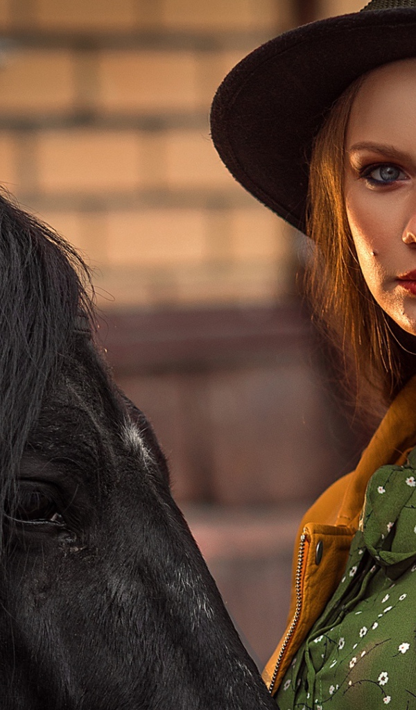 Молодая девушка в черной шляпе с конем 