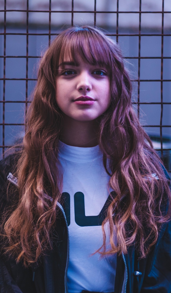 Молодая девушка на фоне железной сетки