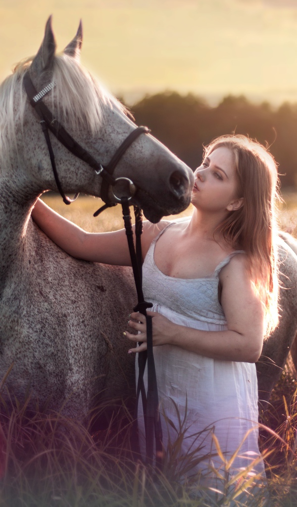 Молодая девушка с лошадью на поле