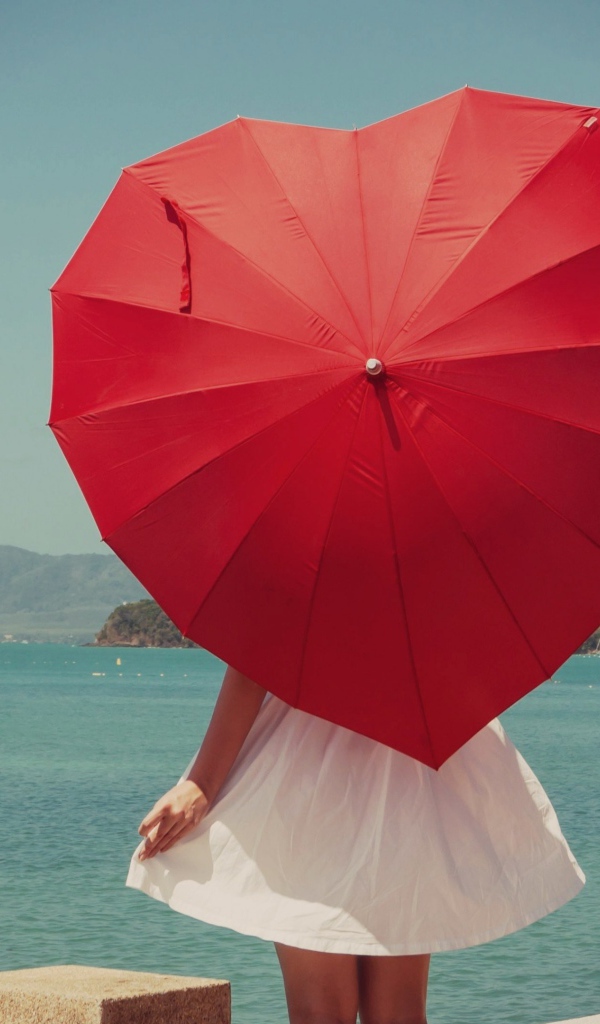 Молодая девушка с красным зонтом в форме сердца