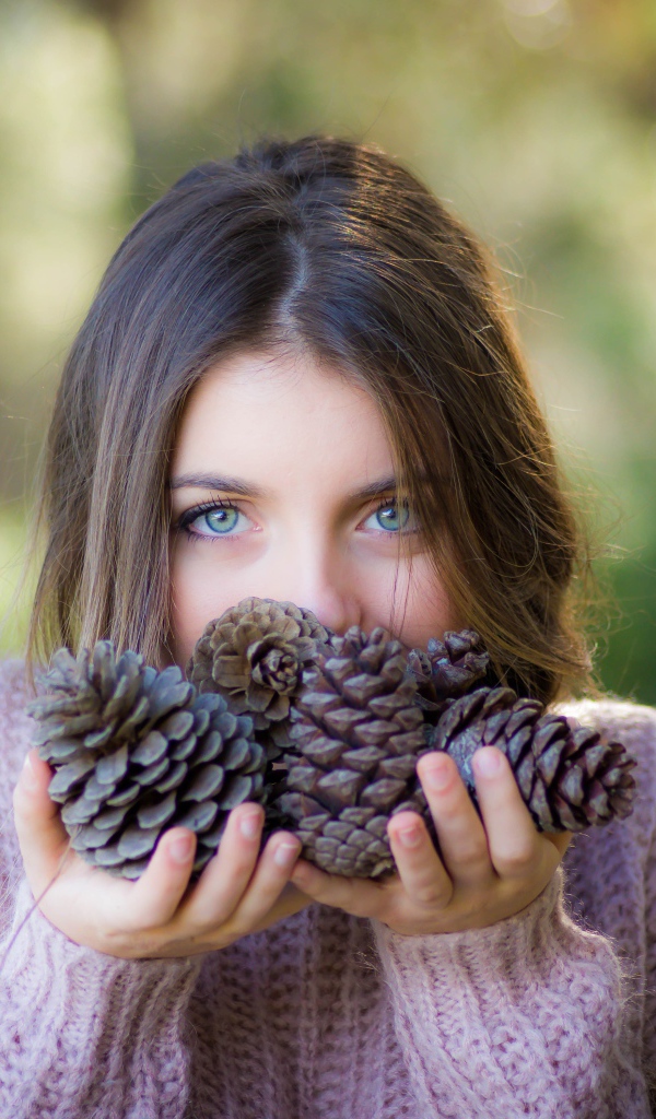 Молодая девушка с шишками в руках