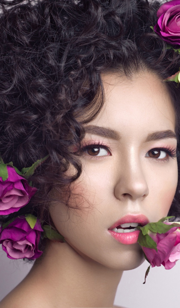 Молодая девушка с кудрявыми волосами с розами