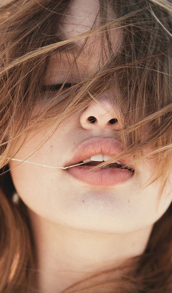 Молодая девушка с распущенными волосами на ветру