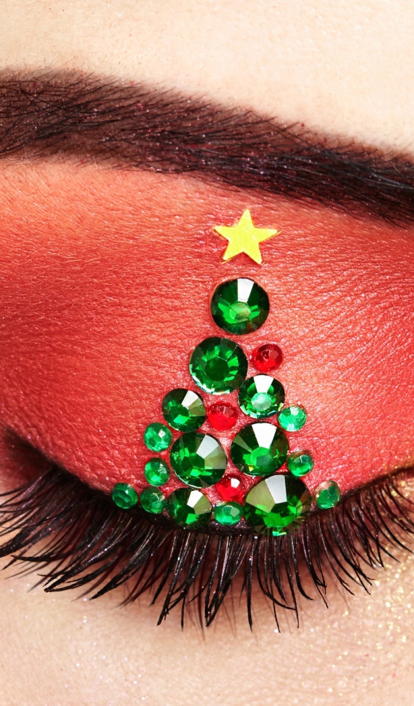 Christmas tree from rhinestones on the eyelid of the girl