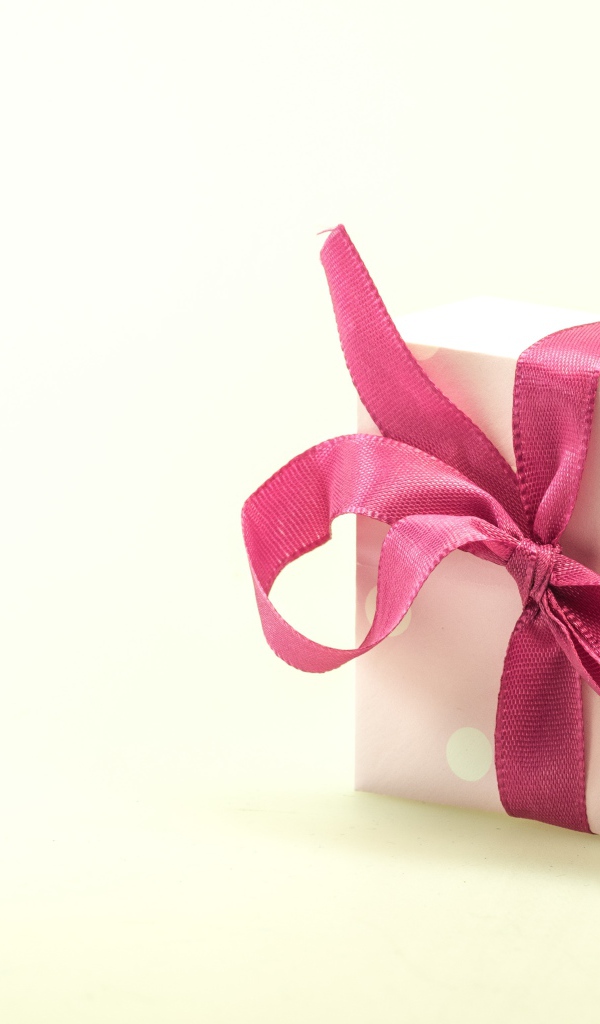 Подарочная коробка с розовым бантом на белом фоне
