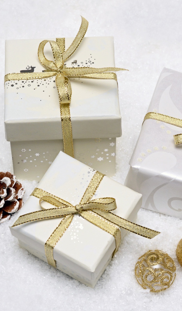 Три коробки с подарками с золотистыми бантами из ленты 