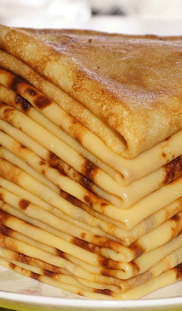 Стопка тонких блинов с ромашкой на Масленицу