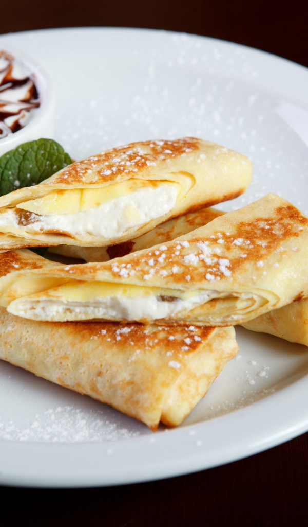 Блины с творогом и сметаной на белой тарелке на Масленицу