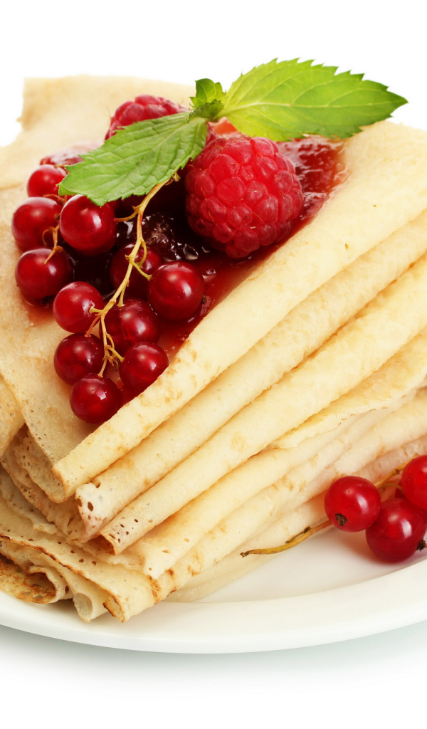 Тонкие блины с малиной и красной смородиной на белом фоне на Масленицу