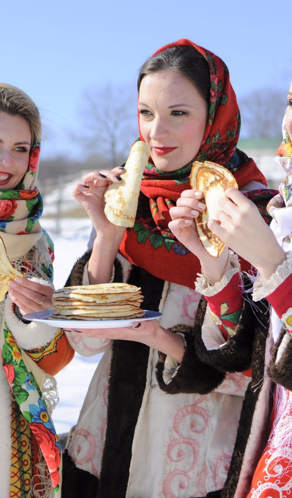 Три молодые красивые девушки с блинами на Масленицу