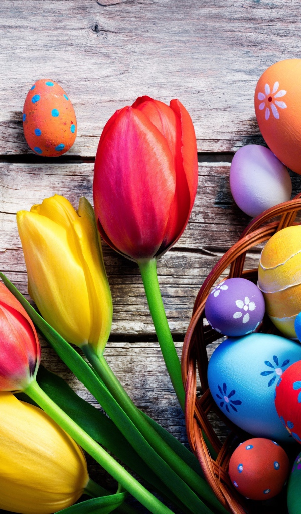 Крашеные яйца на столе с тюльпанами на Пасху