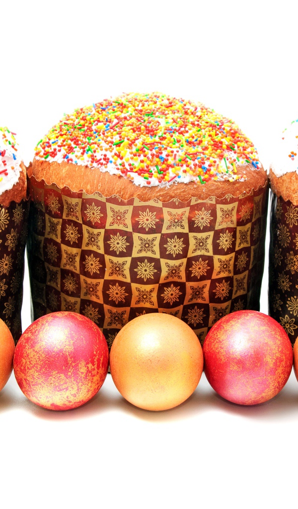 Три пасхальных кулича с крашеными яйцами на белом фоне на праздник Пасха