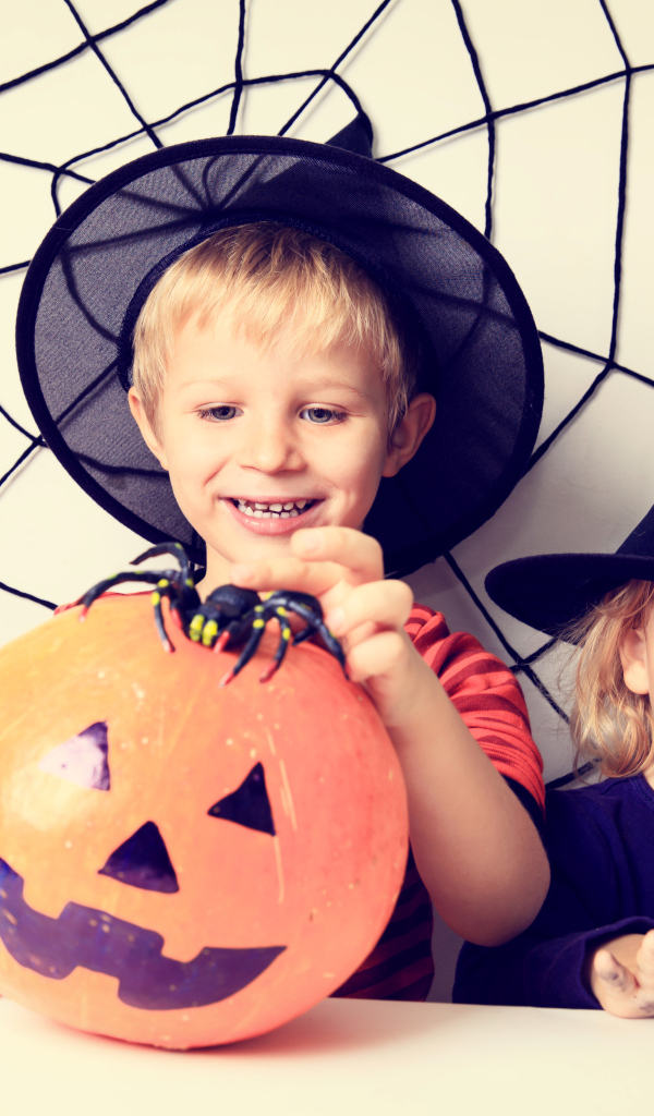 Маленькие мальчик и девочка в костюмах на Хэллоуин