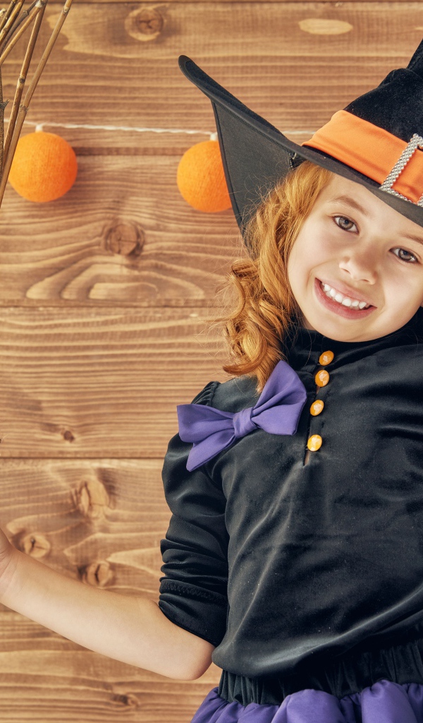 Маленькая девочка в костюме ведьмы на праздник Хэллоуин