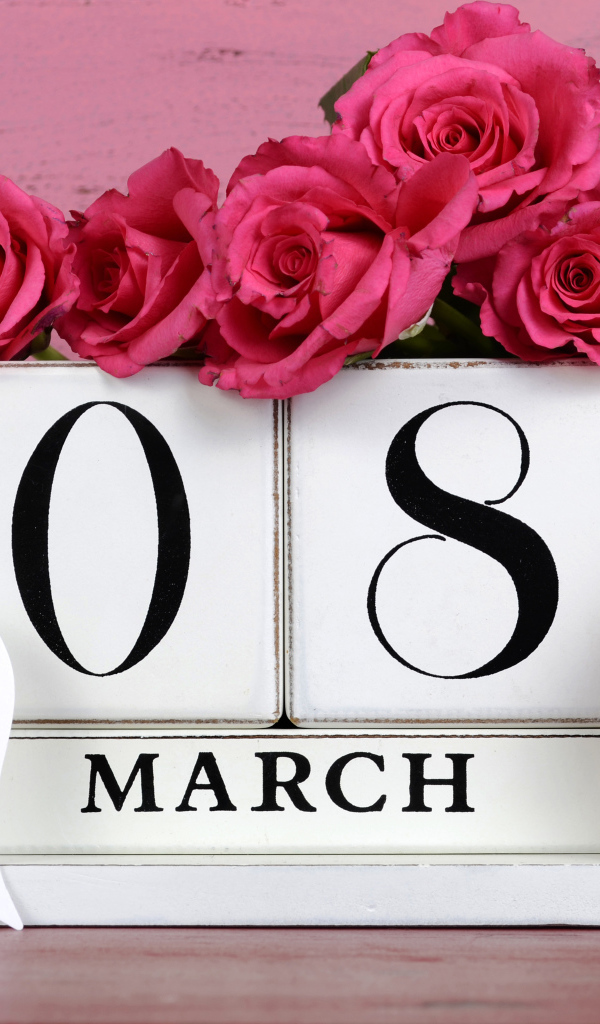 Красные розы на розовом фоне на Международный женский день