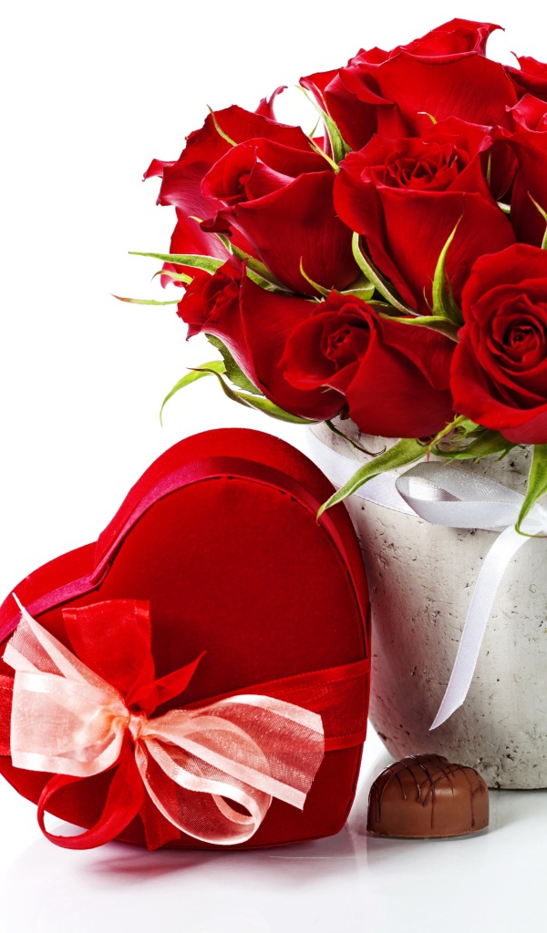 Коробка с конфетами в форме сердца и букет красных роз на белом фоне на День Влюбленных 14 февраля