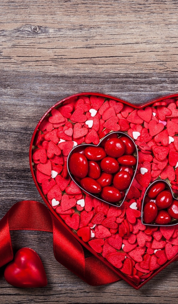 Коробка конфет в форме сердца с красной лентой в подарок