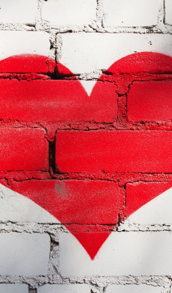 Большое красное сердце нарисовано на кирпичной стене
