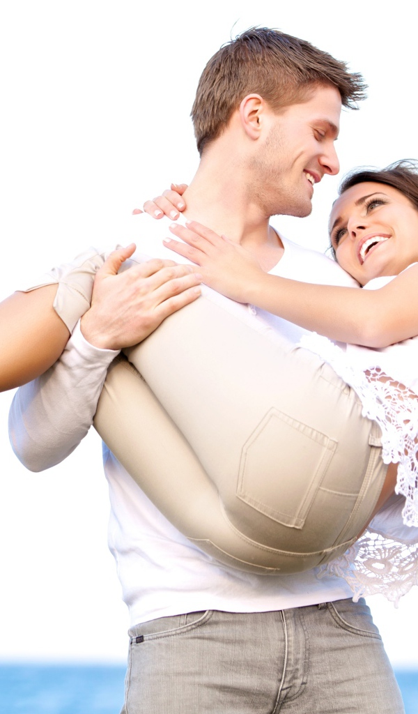 Влюбленный парень держит девушку на руках